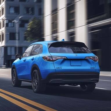 2027 Honda HR-V Sport in Boost Blue Pearl three quarter rear view driving through the city (Subcompact Crossover SUV).